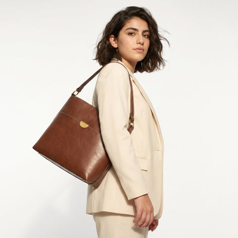 Women's pocket detail bucket bag with magnetic button closure, front view